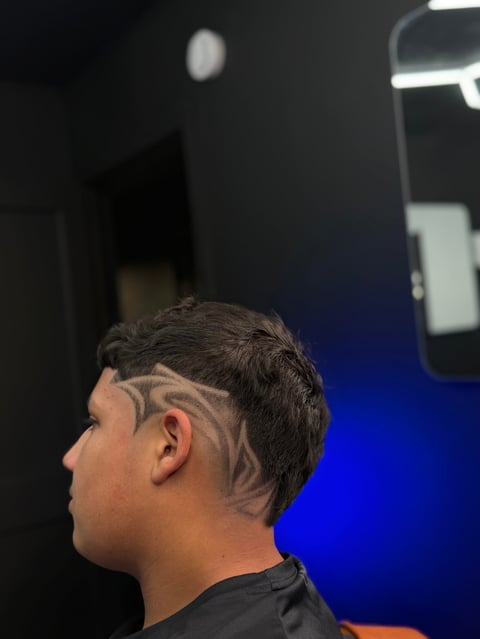 Profile view of person with dark hair and geometric line tattoo design on head and neck